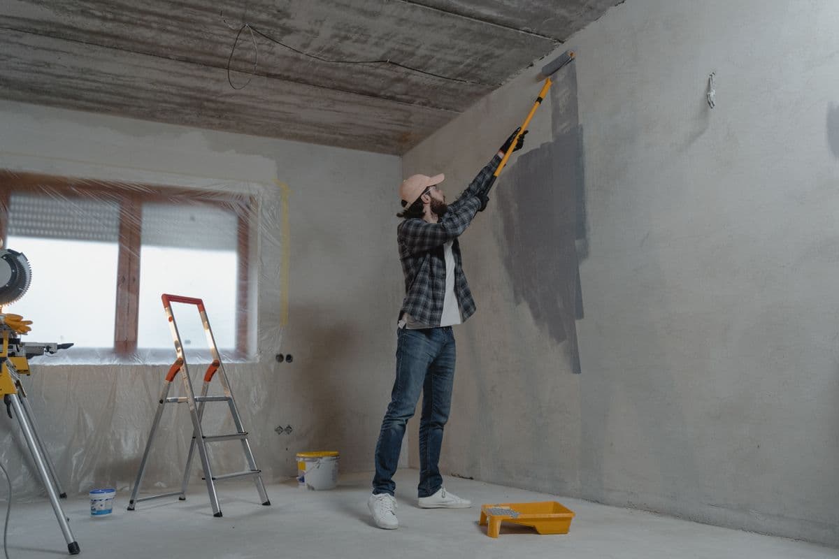 Painter rolling paint onto a wall
